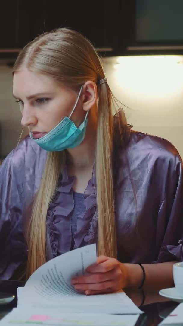 Woman in pajama and with medical mask signing documents — Stock Video