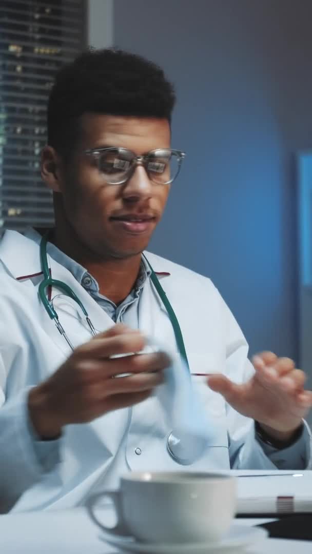 Fotografie medie a unui tânăr medic african care arată cum să poarte mască medicală prin apel video pe calculator — Videoclip de stoc