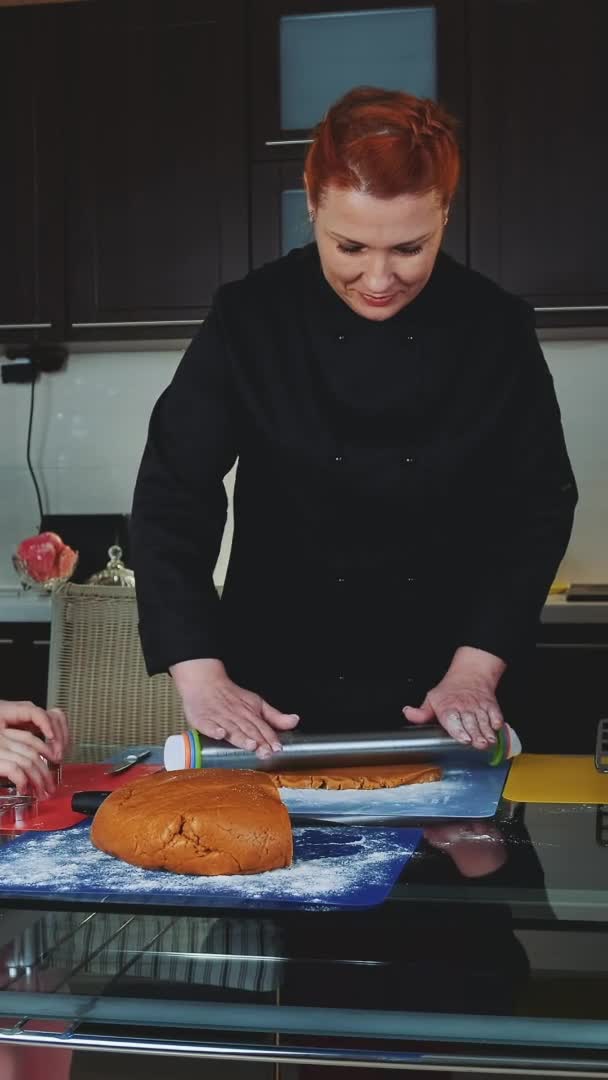 Dos mujeres y una niña haciendo preparaciones para hornear galletas en la cocina — Vídeo de stock