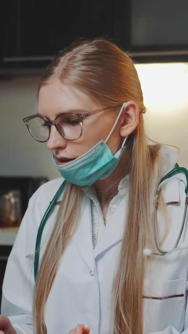 Médica em vestido médico fazendo videochamada para paciente de casa — Vídeo de Stock