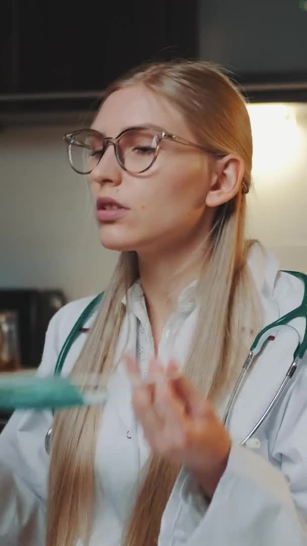 Doctora que muestra cómo usar máscara médica por videollamada en la computadora — Vídeo de stock