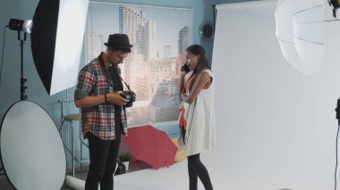 Fotoğrafçı çalışmaya devam etmek isterken Afrikalı çekici bir model akıllı telefondan konuşuyor.
