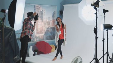 Fotoğraf çekimindeki sahne arkasında: Fotoğrafçı güzel siyah modelin fotoğraflarını çekiyor.