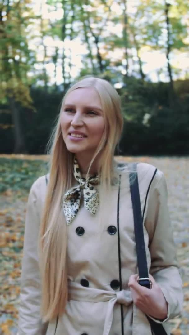 Bella ragazza bionda che cammina nel parco in autunno — Video Stock