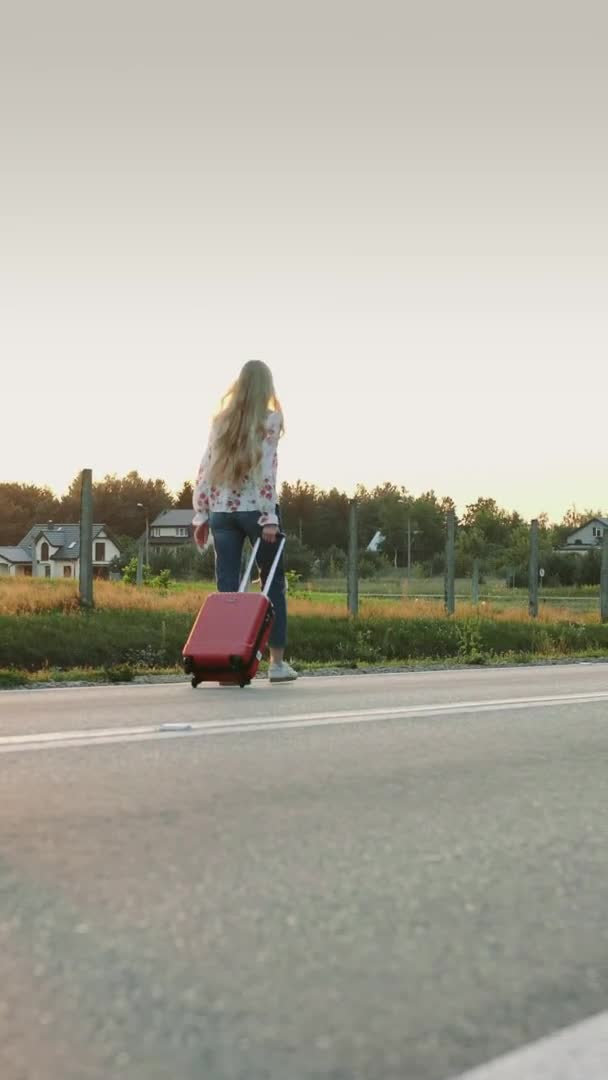 Mujer alegre con maleta caminando por el camino . — Vídeo de stock