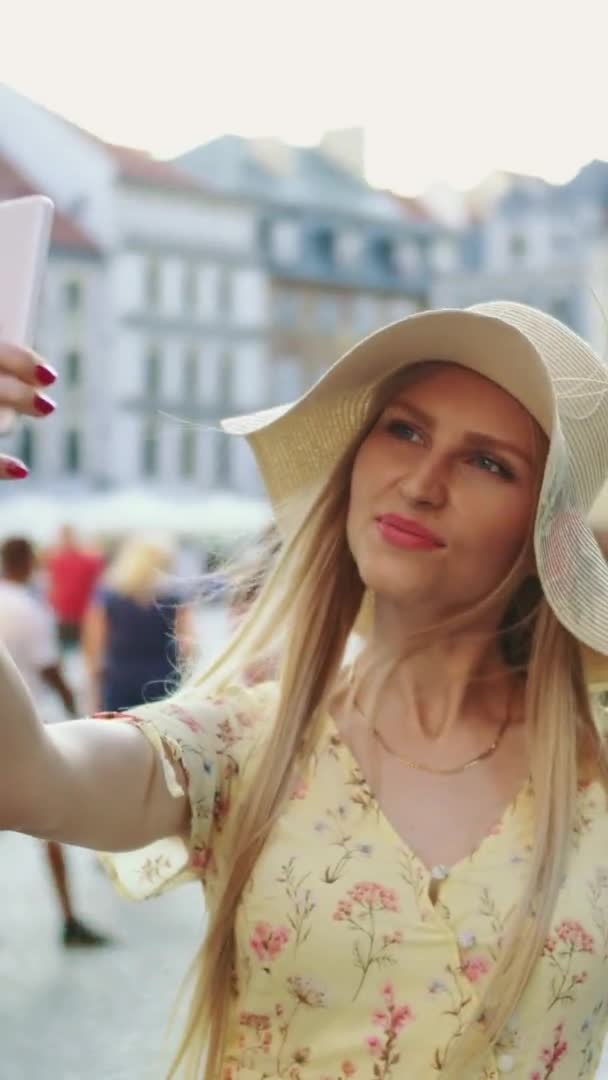 Mujer tomando selfie en la plaza. Mujer atractiva posando para selfie y de pie en la plaza de la ciudad . — Vídeo de stock