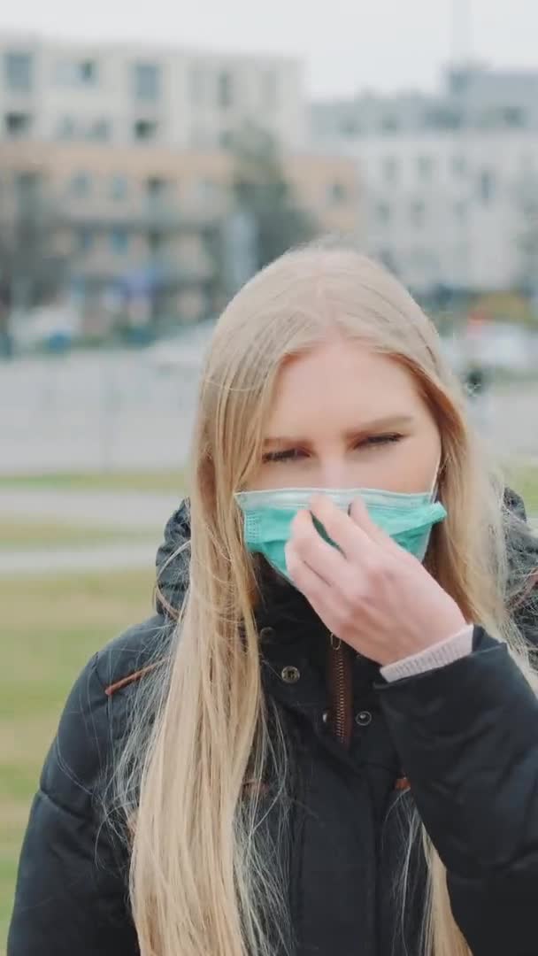 Mujer poniendo una máscara médica en su cara en la calle — Vídeos de Stock