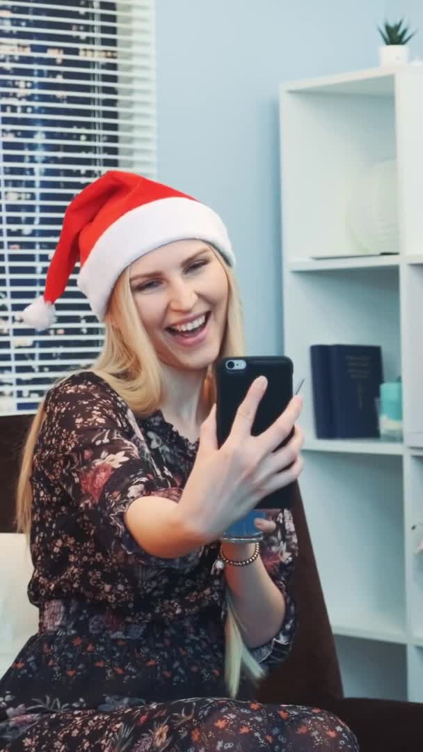 Medium närbild av trevlig flicka gör selfie i Santa hatt och med dryck i händerna — Stockvideo