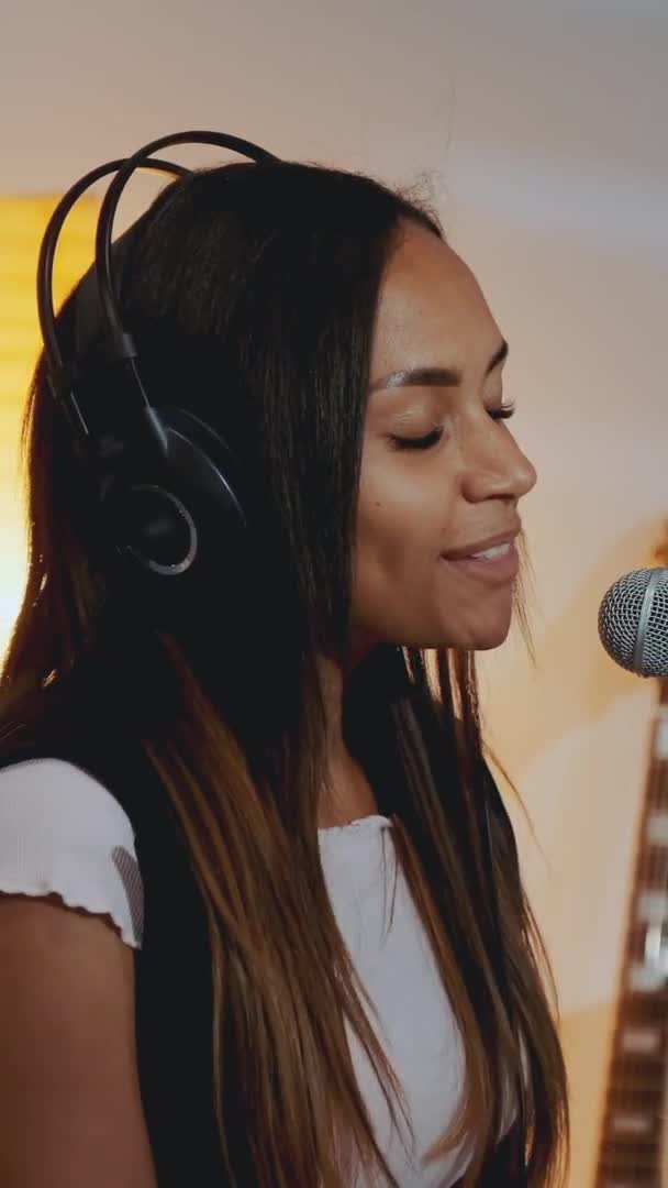 Close-up van mooi lachend meisje in hoofdtelefoon die haar favoriete liedje zingt op de repetitie — Stockvideo