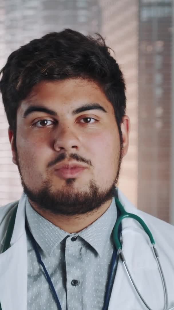 Close-up of multiracial doctor in lab coat and with stethoscope telling something — Stock Video