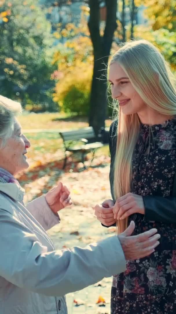 Бабуся і онука обнімають один одного в парку — стокове відео