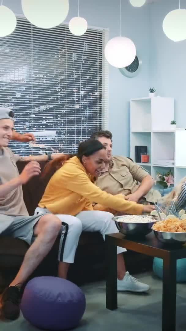 Wieloetniczni przyjaciele spadają na sofę oglądać telewizję — Wideo stockowe