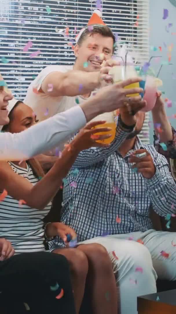 Close up of cheerful company celebrating Christmas in confetti blowing — Stock Video