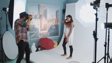 Profesyonel stüdyo fotoğraf çekiminde fotoğrafçıya poz veren güzel melez kız.