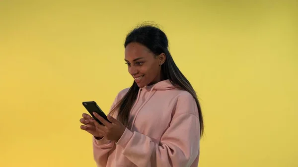 Ganska svart kvinna att hitta något otroligt surfa på Internet på smartphone — Stockfoto