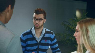 Rapor üzerinde çalışan çok ırklı erkek ve kadın. Modern ofis salonunda çeşitli kadın ve erkek grupları belgeler ve istatistikler üzerinde çalışıyorlar..