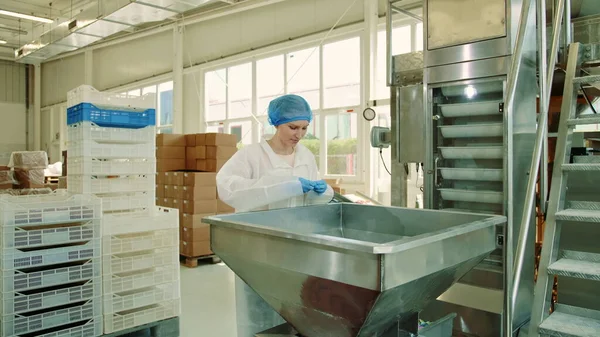 Fábrica de dulces. Trabajador de fábrica comprobando máquina de embalaje . — Foto de Stock
