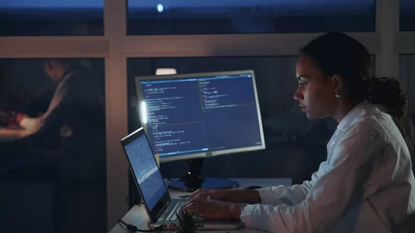 Side view of african american female engineer working on computer in electronics laboratory. Doing Development of Software and Hardware.