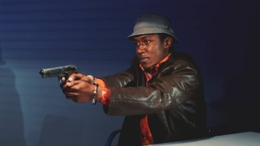 Siyah suçlunun silahı kapıp polislere zarar vermekle tehdit ettiği yakın plan.