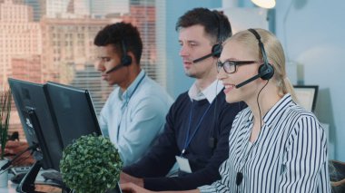 Medium shot of female customer service working in busy call center by talking to the international client