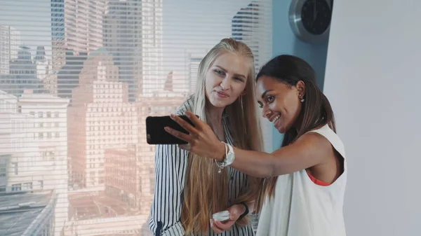 Behind the scenes on photo shoot: make-up artist applying makeup on model while she making selfie — Stock Photo, Image