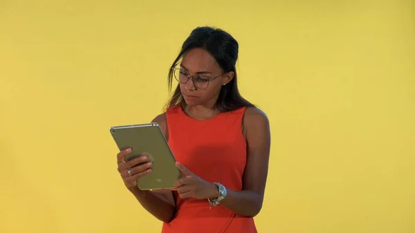 Black business woman in dress and eyeglasses analysing something on tablet. — Stock Photo, Image