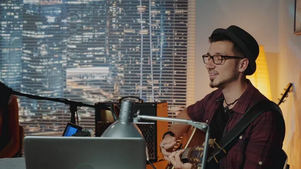 Yakışıklı hipster 'ın mikrofona şarkı söyleyip gitar çaldığı profil görüntüsü.
