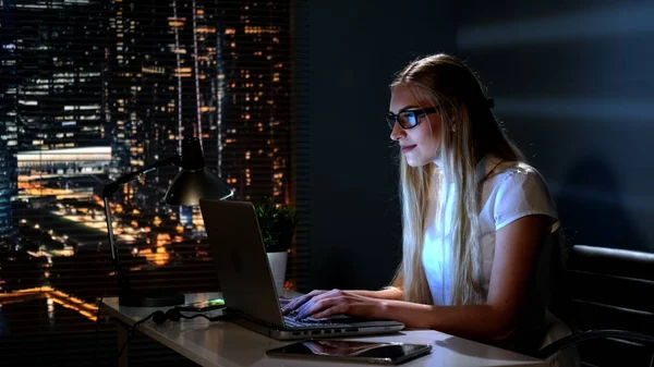Mutlu genç bir kadın gece geç saatlerde internet dükkanından karlı bir alışveriş yapıyor.