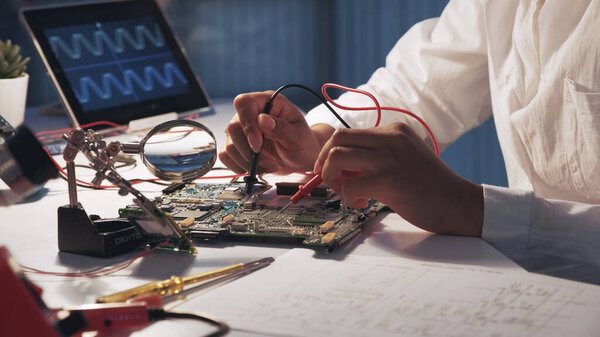 View of womans hands testing motherboard in laboratory
