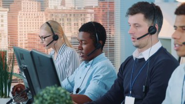 African customer service representative working on multiracial team of modern call center