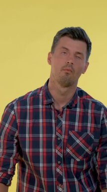 Kareli gömlekli sıkıcı bir adam parmak tabancasıyla kendini başından vuruyor ve sonra da yere düşüyor..