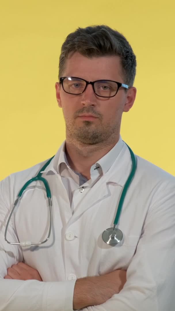 Portret młodego lekarza w fartuchu laboratoryjnym zaprzeczającego czemuś przed kamerą — Wideo stockowe