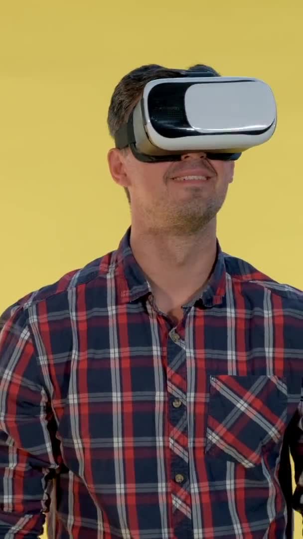 Χαρούμενος νεαρός άνδρας εκπλήσσεται με τη χρήση γυαλιών εικονικής πραγματικότητας — Αρχείο Βίντεο