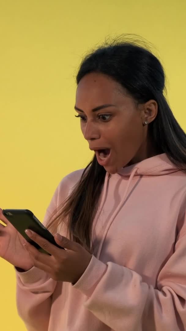 Pretty black woman finding something incredible surfing the Internet on smartphone — Stock Video