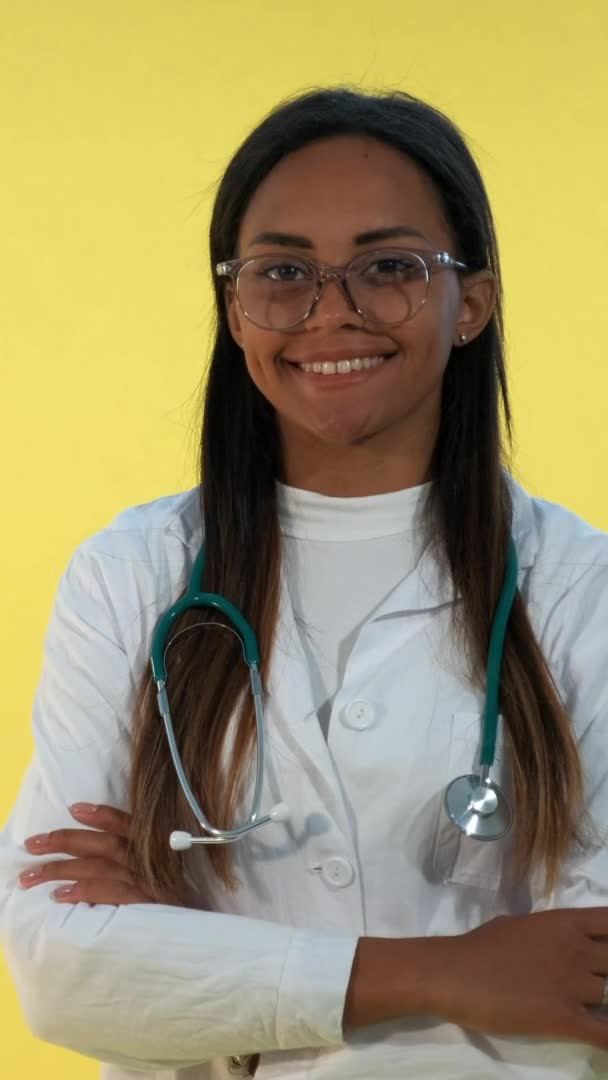 Retrato de la doctora africana sonriendo a la cámara sobre fondo amarillo . — Vídeos de Stock