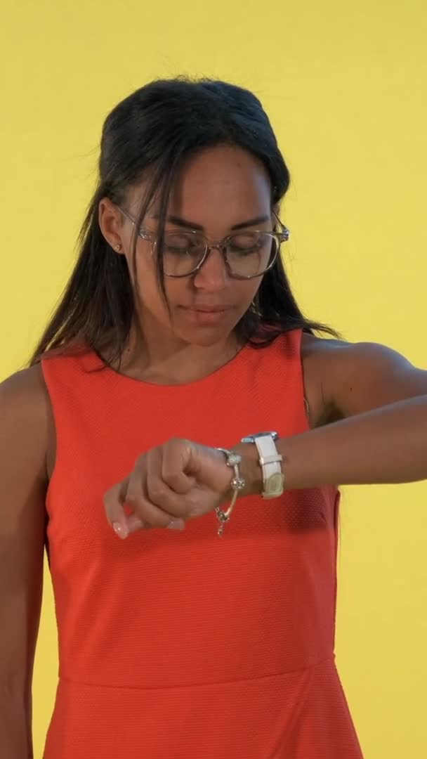 Mujer negra de aspecto agradable está esperando a alguien y comprobar el tiempo — Vídeo de stock