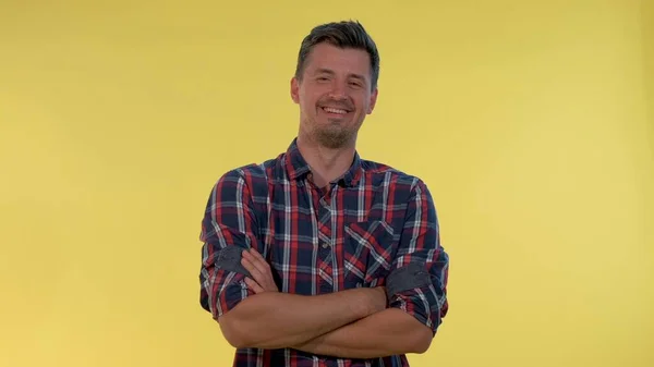 Jovem feliz irrompendo no riso no fundo amarelo. Ele está de camisa quadriculada. . — Fotografia de Stock