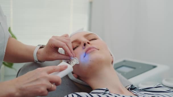 Close-up shot van professionele cosmetoloog maken cavitatie peeling op jonge vrouwen gezicht — Stockvideo