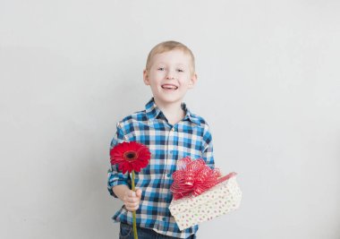 Kırmızı çiçek ve hediye ile küçük çocuk