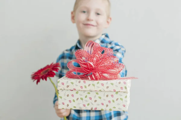 Маленький мальчик с красным цветом и подарочной коробкой — стоковое фото
