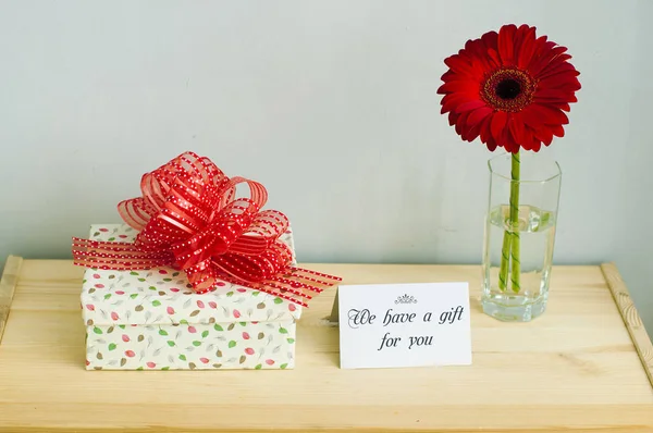 Regalo, tarjeta de felicitación y flor — Foto de Stock