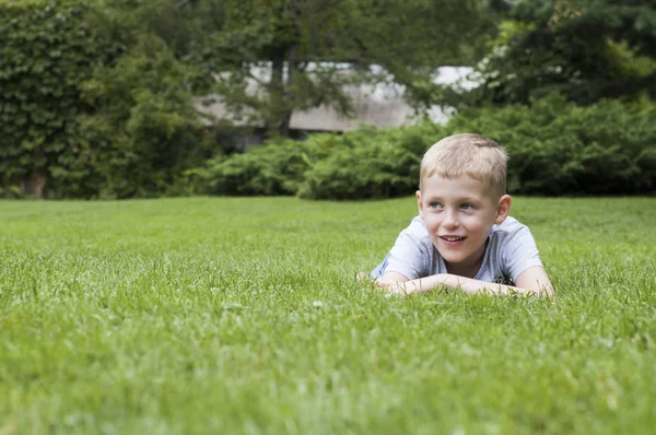 Uśmiechnięte dziecko na zielonej trawie — Zdjęcie stockowe