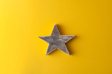 wooden star on bright yellow background