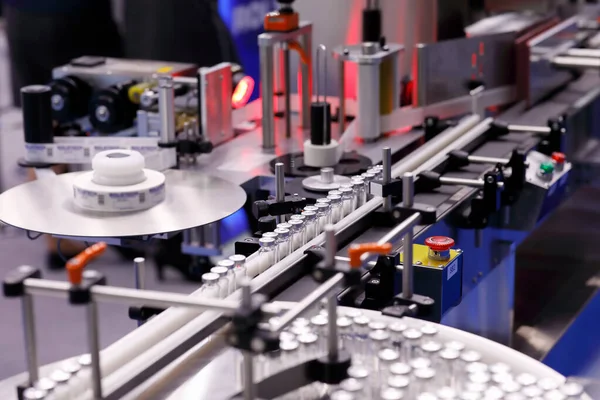 İğne için ilaç şişeleri için otomatik yapıştırıcı etiketleme makinesi. Seçici odak.