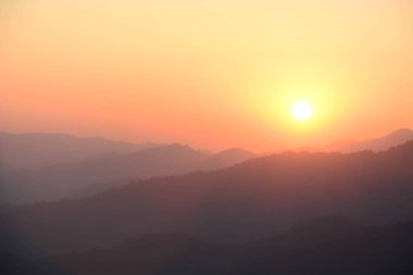 Turuncu gökyüzü günbatımı siluet dağ manzara arka plan bulanık.