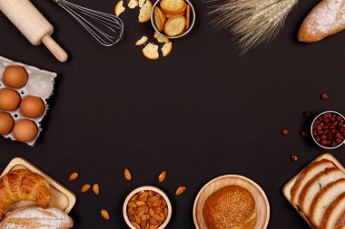 Ev yapımı ekmek ya da topuz, kruvasan ve ekmek malzemeler, un, badem fındık, fındık, yumurta koyu arka plan, fırın arka plan çerçeve, yemek kahvaltı kavramı. Düz yatıyordu, en iyi görünüm ve kopya alanı.