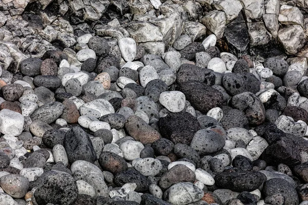 Pietre nere vulcaniche arrotondate sulla spiaggia — Foto Stock