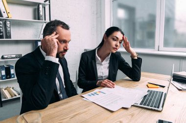 yorgun iş arkadaşları kağıtları ve office içinde laptop ile işyerinde takım elbiseli