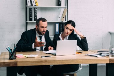 yorgun iş arkadaşları kağıtları ve office içinde laptop ile işyerinde takım elbiseli