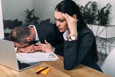 overworked işadamı ve yorgun iş meslektaşım belgeler ve office içinde laptop ile işyerinde